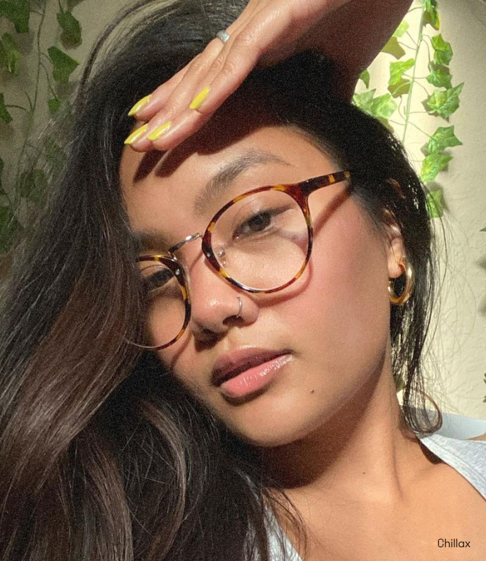 A woman with long hair wearing reading glasses